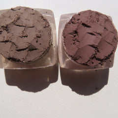 Close-up of four matte brown loose mineral eyeshadows in vegan powder form with soft texture