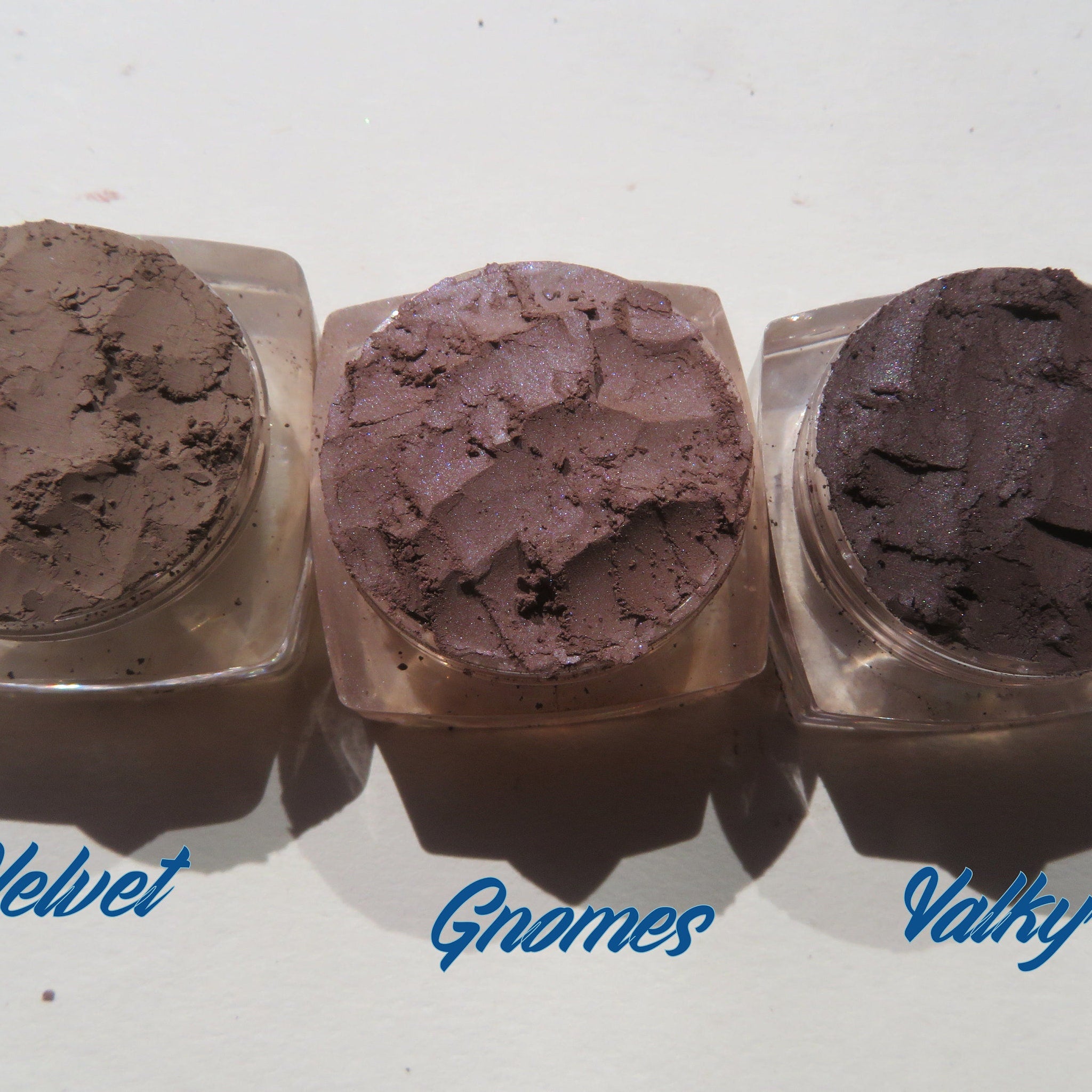Hand applying matte brown mineral eyeshadow with a brush, showcasing loose powder texture and blendability