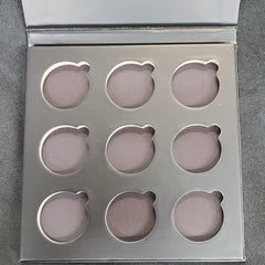 Matte black rectangular eyeshadow palette with nine square pans in neutral shades, magnetic closure