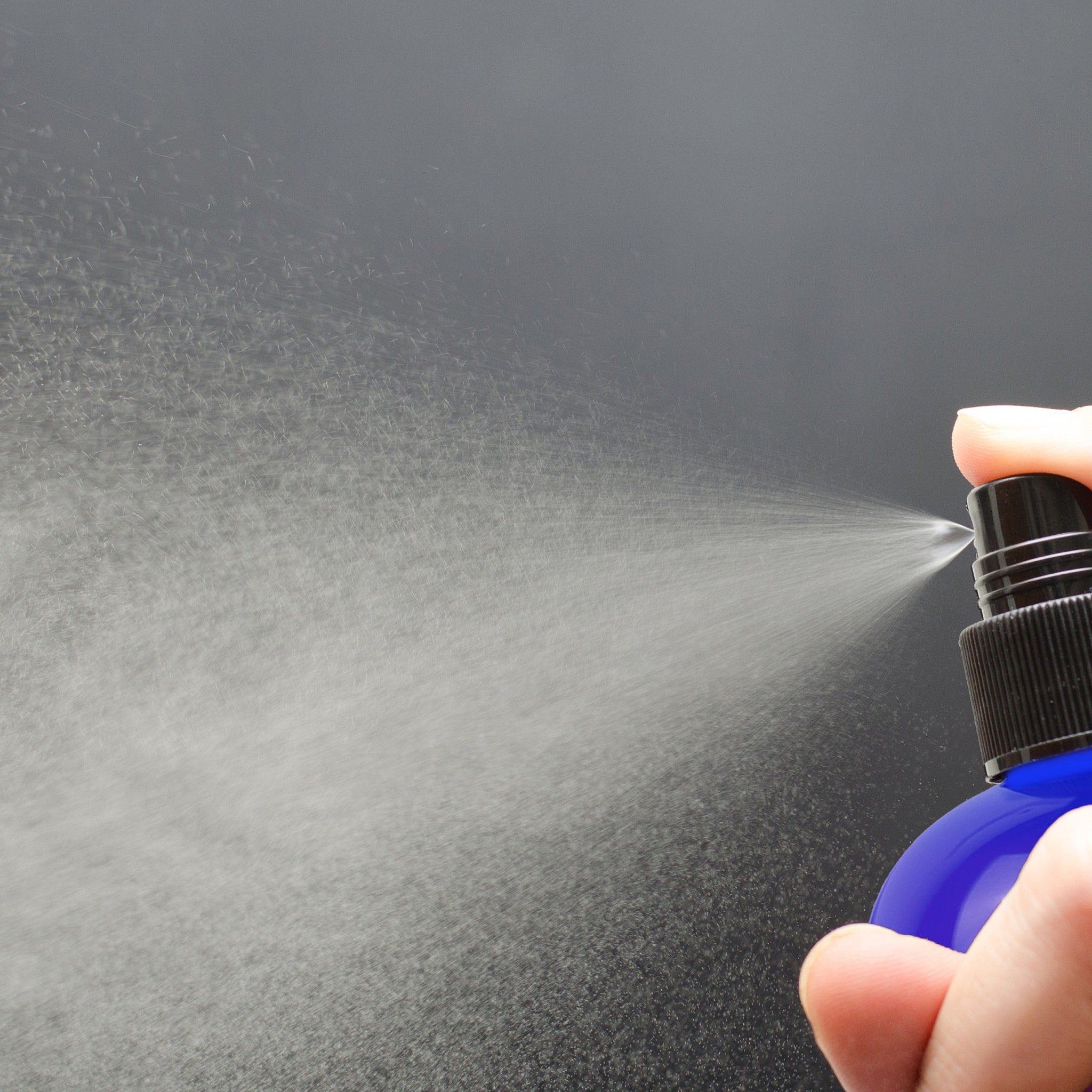 Spray bottle with blue bottle, black cap, and white spray misting