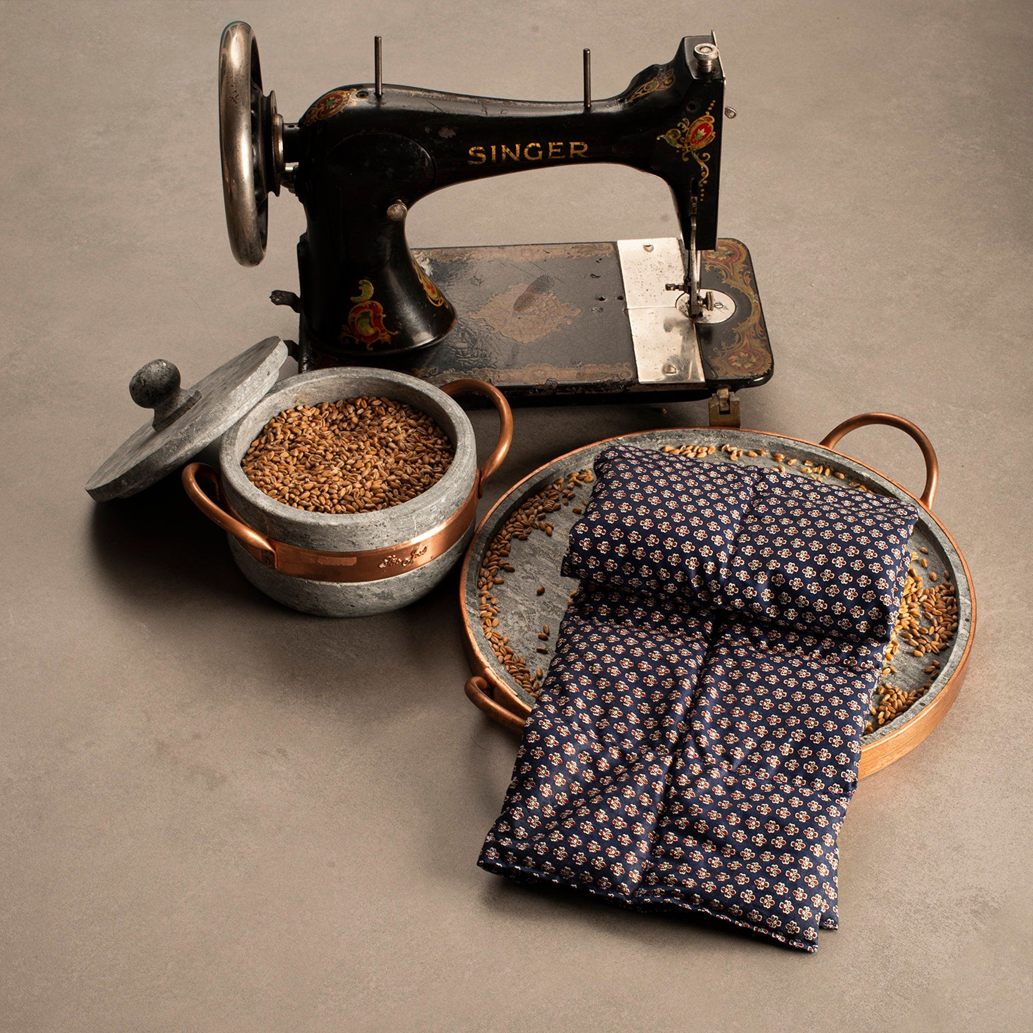 Sewing machine with black and gold details, Singer brand, and blue floral patterned fabric on a tray