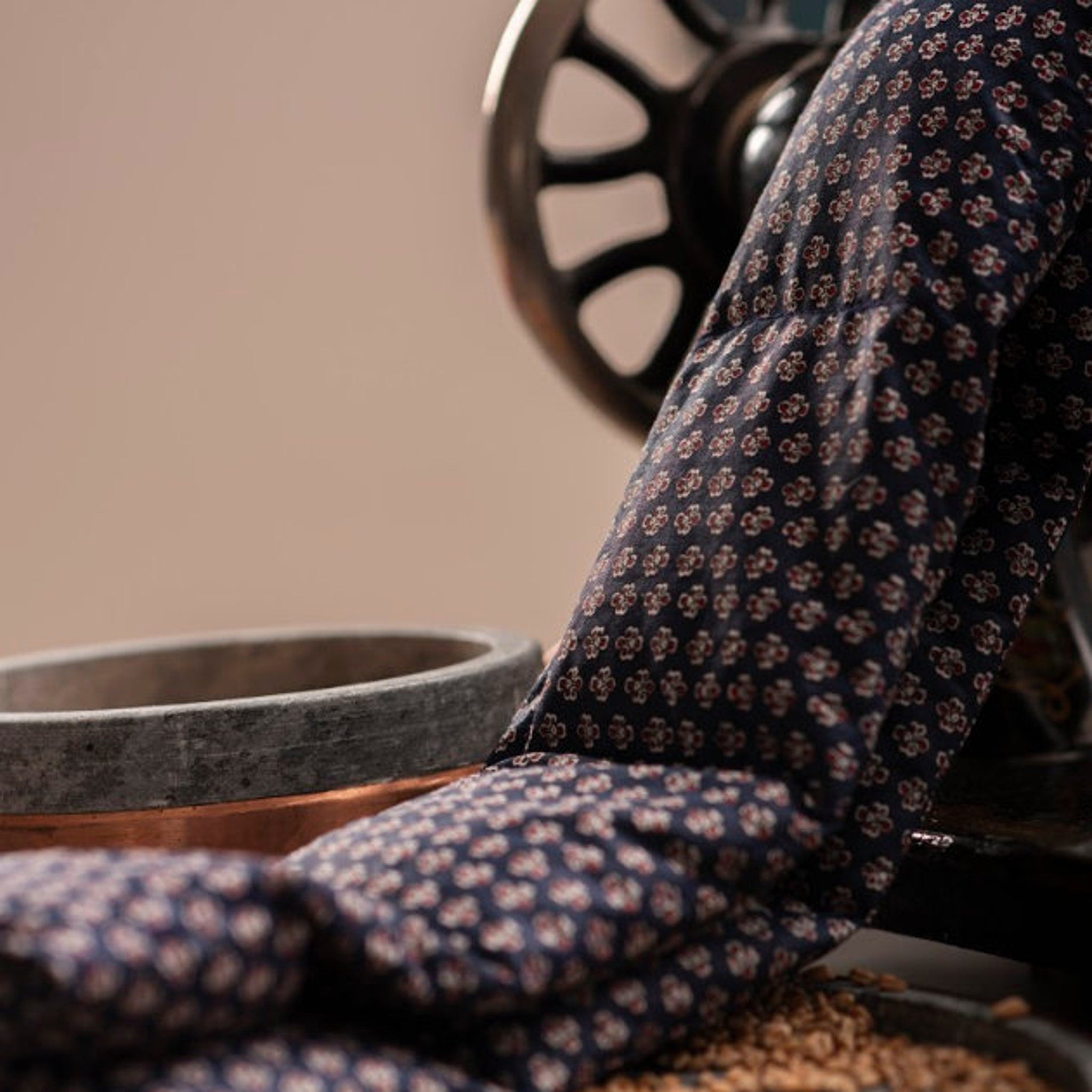 Dark blue floral fabric draped over a machine with a stone bowl