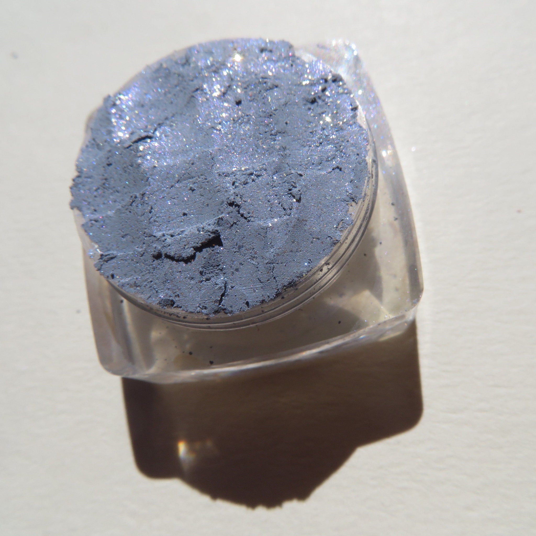 Close-up of sparkling Galactic Blue Gray loose mineral eyeshadow with shimmering mica particles