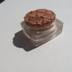 Hand applying bronze copper brown shimmer loose mineral eyeshadow with a fluffy brush for a soft, blended look