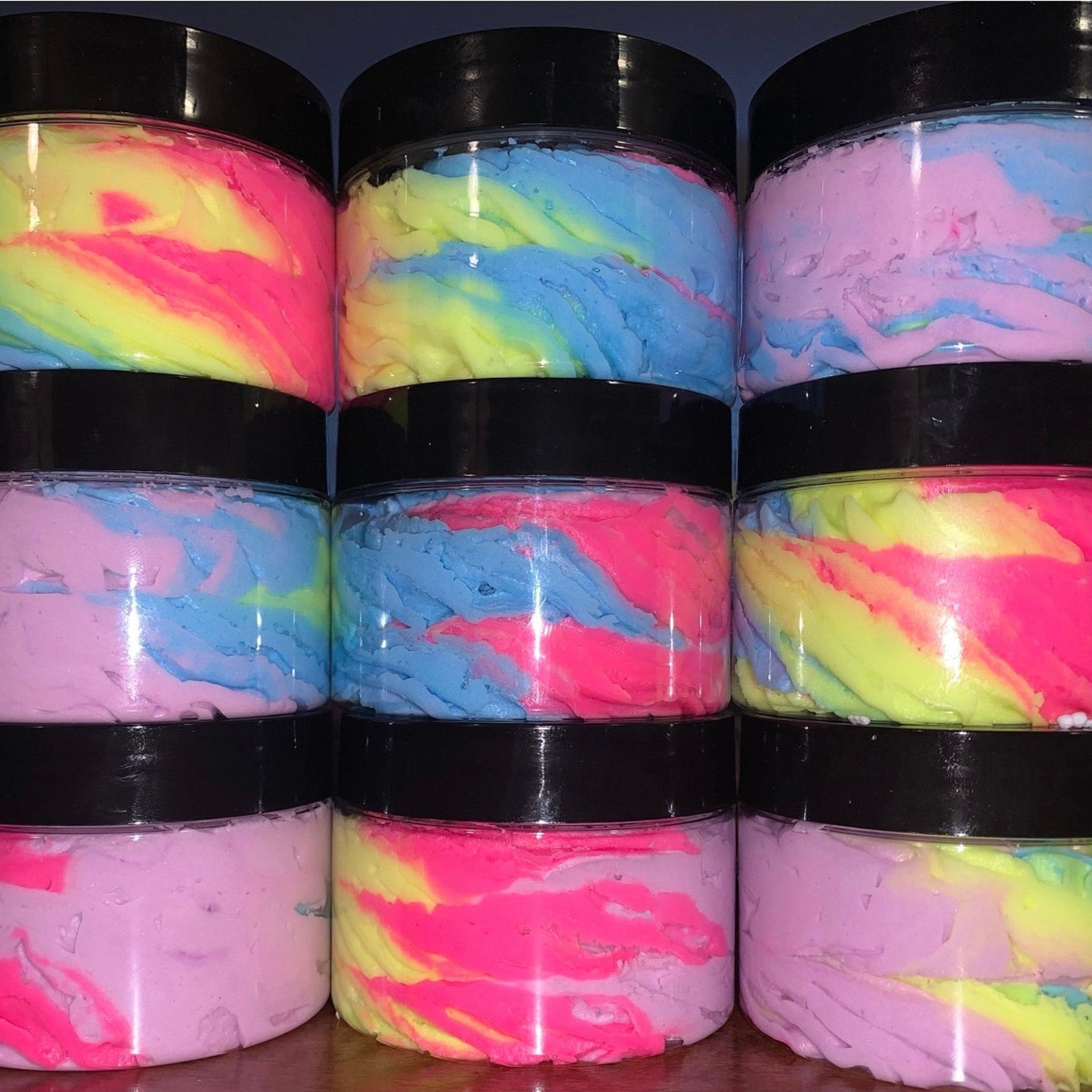 Close-up of whipped unicorn body butter in a pastel pink jar with iridescent swirls and creamy texture