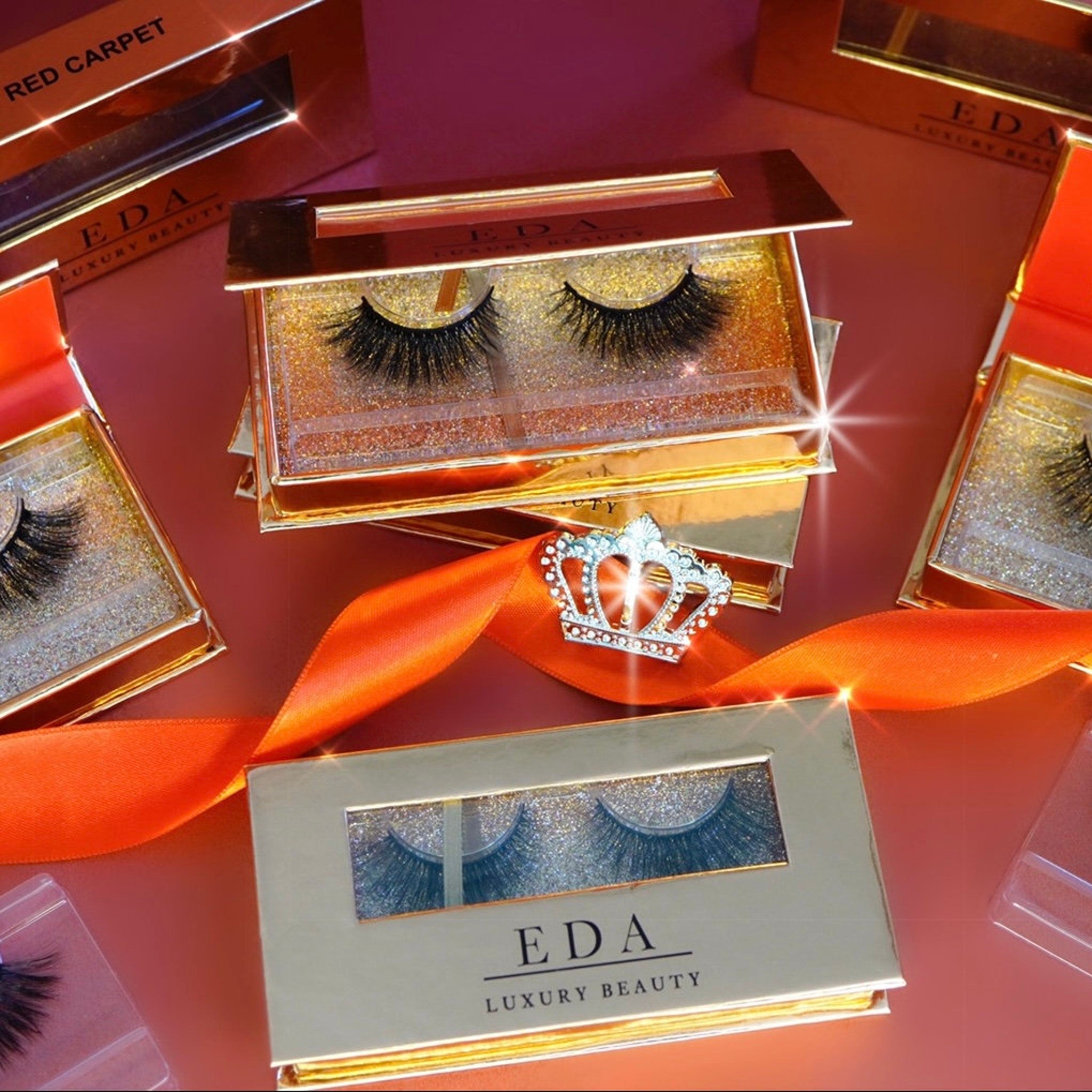 False eyelashes with black lashes, gold glitter, and Eda Luxury Beauty branding in boxes