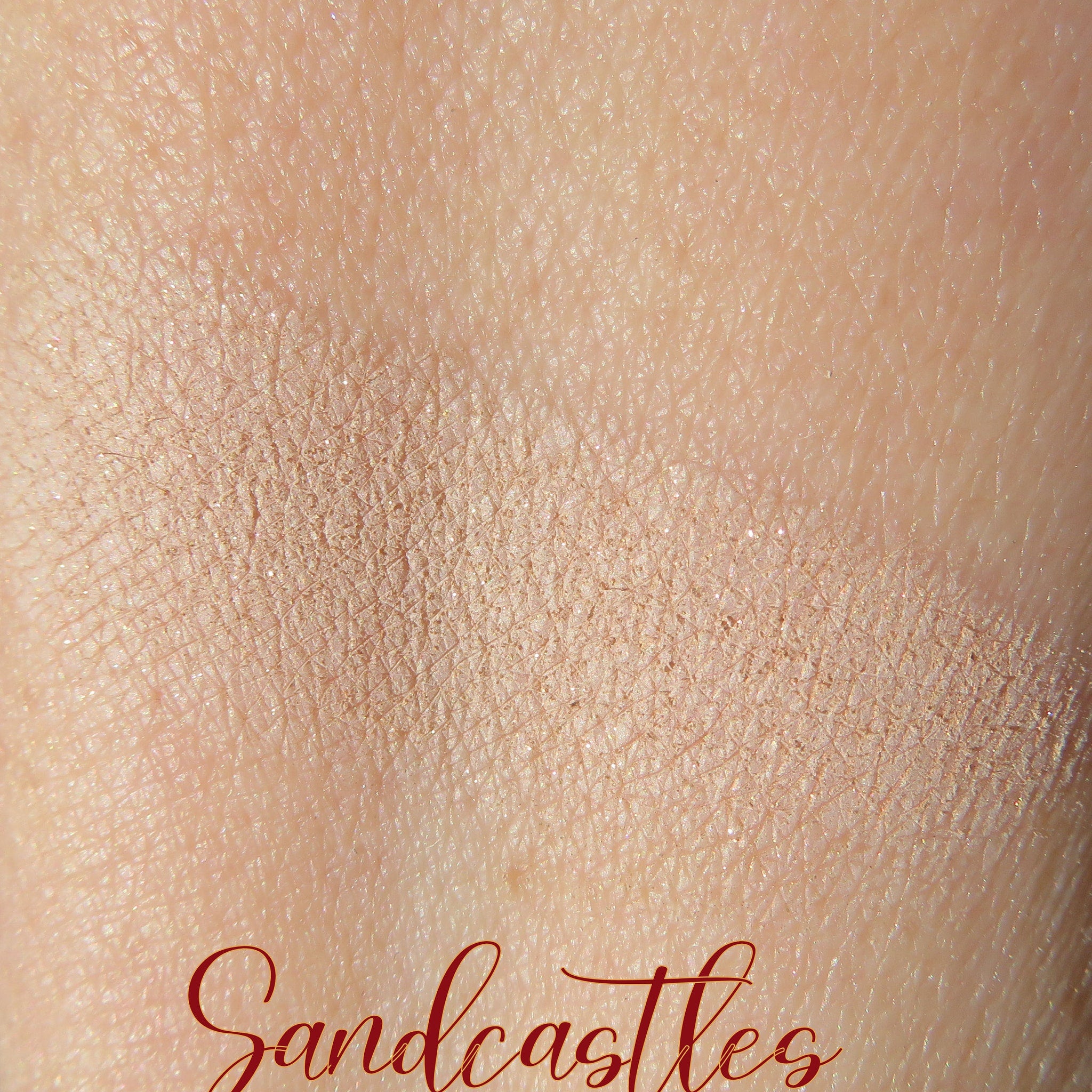 Side view of loose mineral eyeshadow in pale beige and sandy brown shimmer, showcasing eco-friendly packaging texture