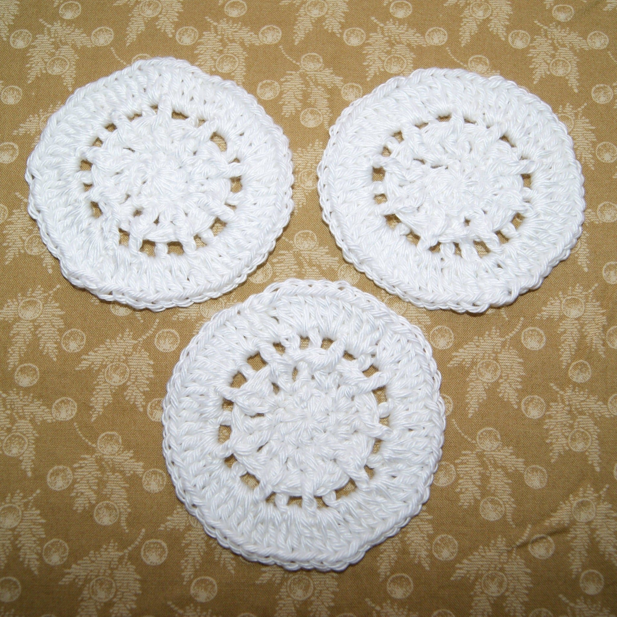 Crochet coasters white cotton round design on patterned background