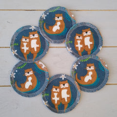 Coasters with otter print, blue fabric, white stitched edge, and floral accents
