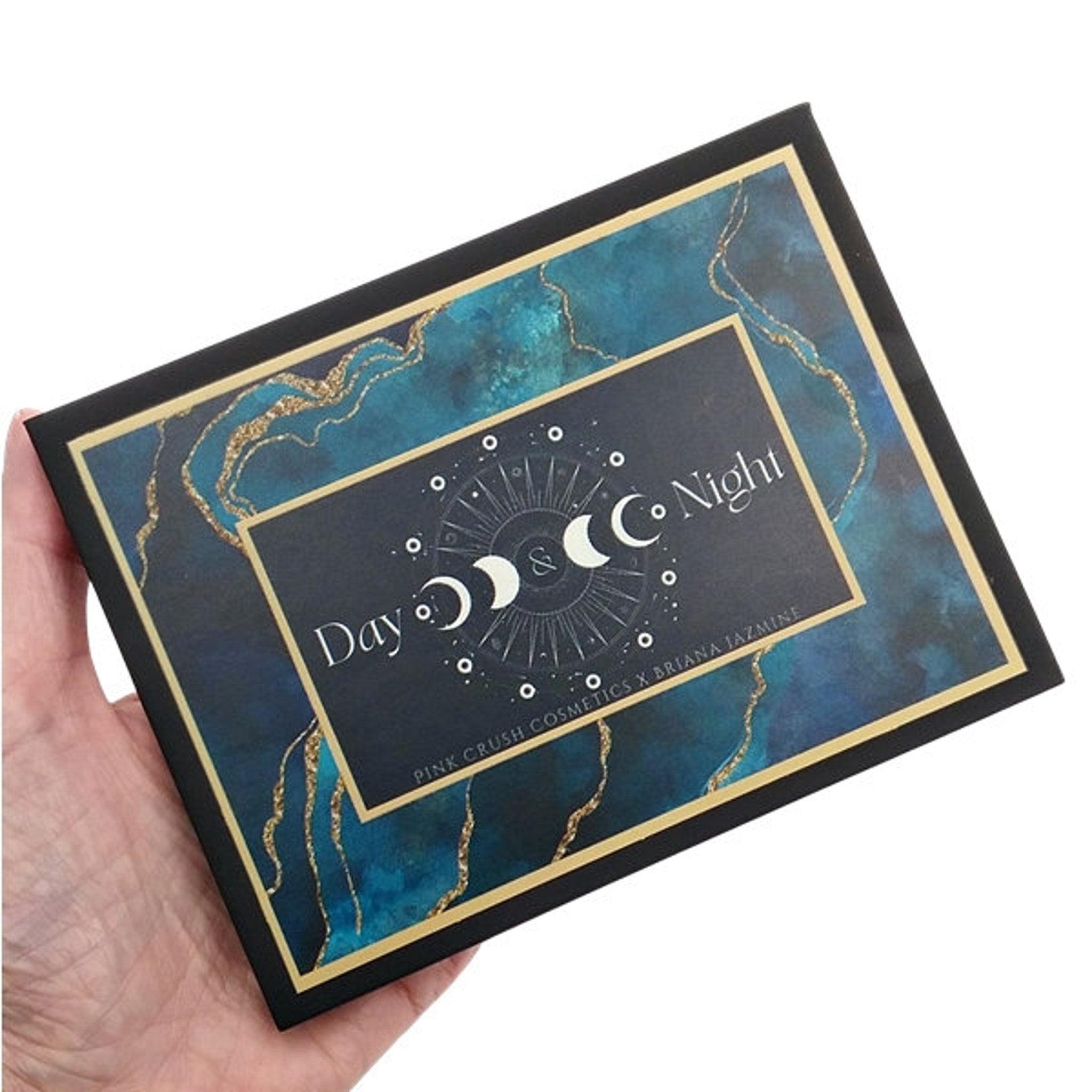 Close-up of shimmering bronze and deep plum eyeshadow pans in sleek black palette