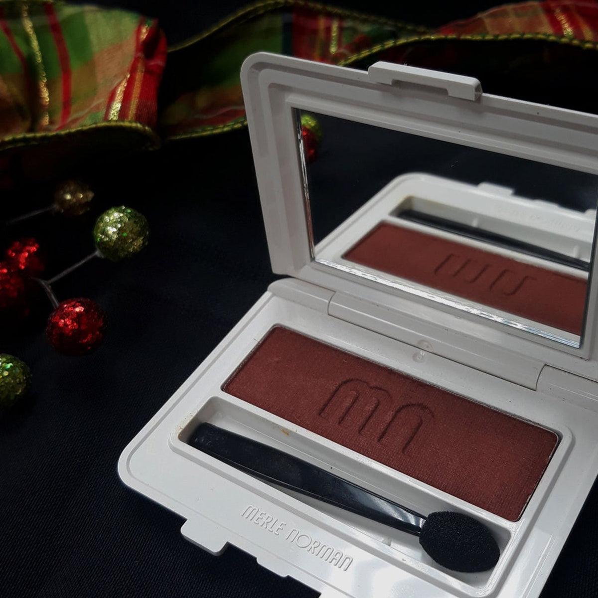 Merle Norman Luxiva single eye shadow compact in rich brown, soft pink, and deep purple shades with sleek mirrored case