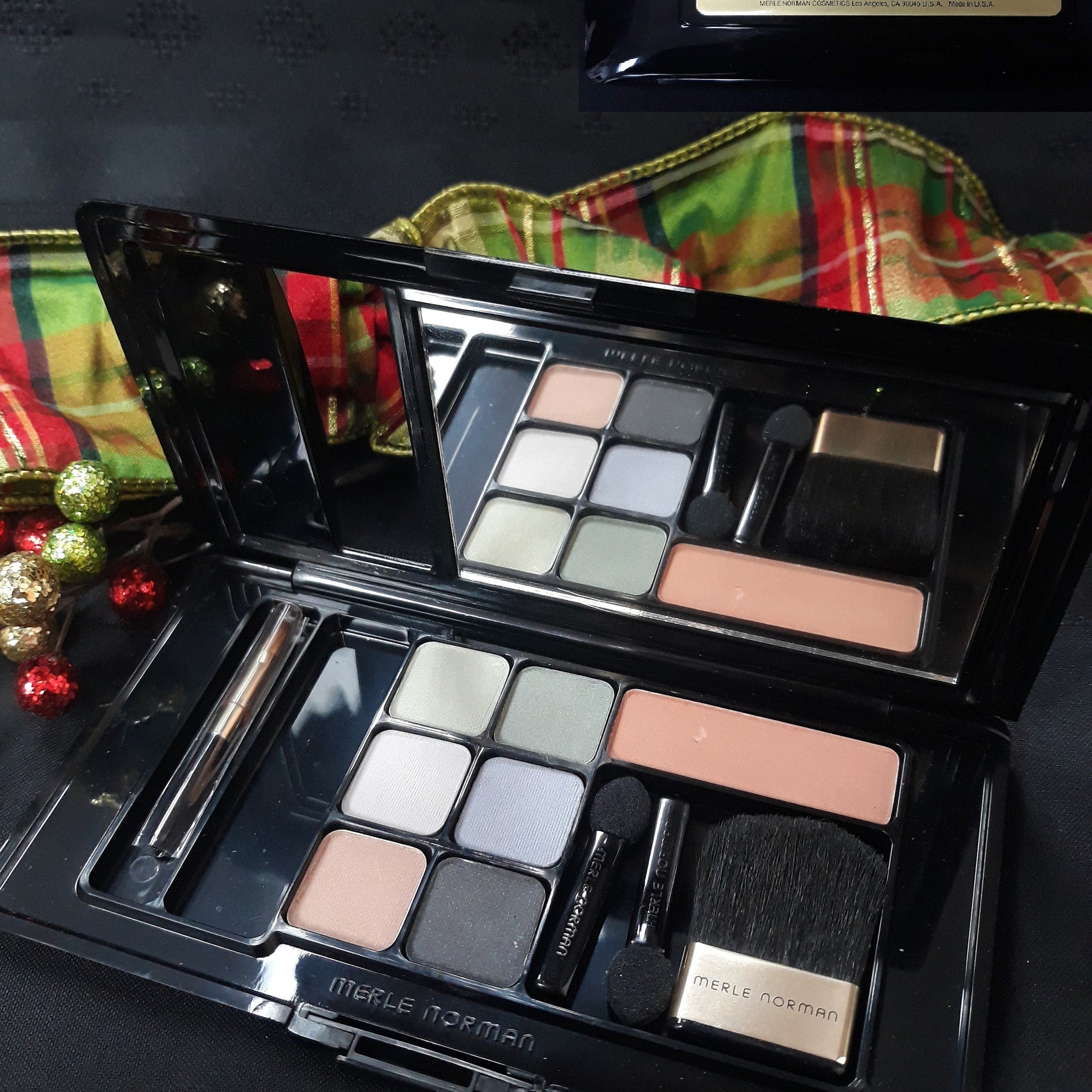 Side view of Merle Norman Luxiva compact showing six shimmering eyeshadow shades and two blush pans