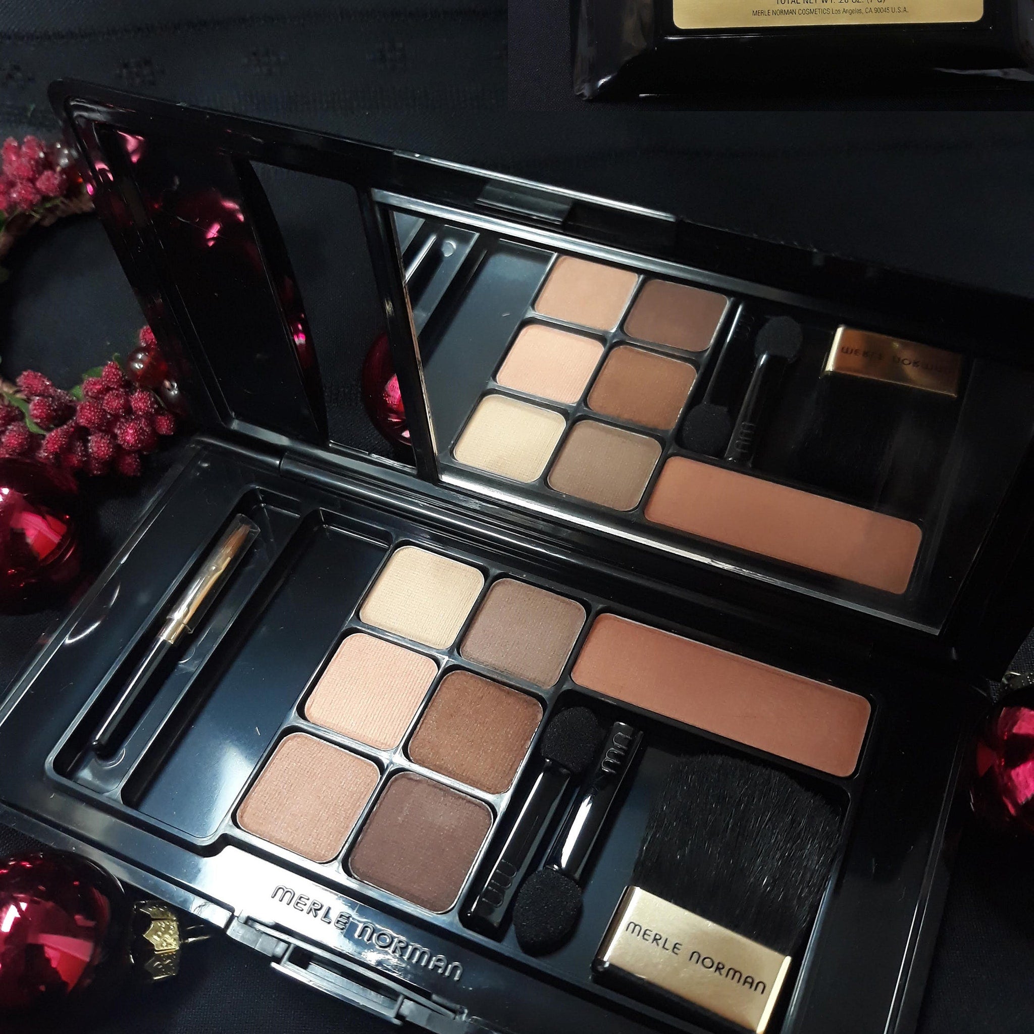 Open compact showing six shimmering eyeshadows in bronze, gold, and pink with two blush pans