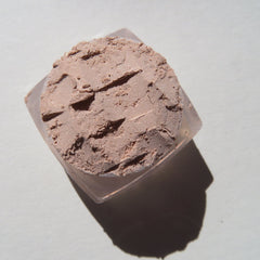 Close-up of loose shimmering eyeshadow in pale beige and sandy brown tones with eco-friendly mineral pigments