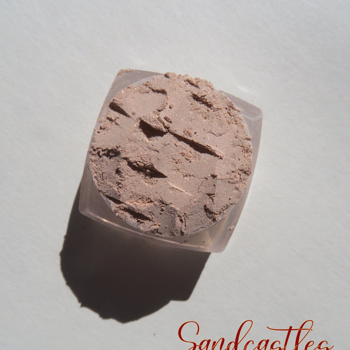 Pale beige and sandy brown shimmer loose mineral eyeshadow in eco-friendly packaging with vegan formula