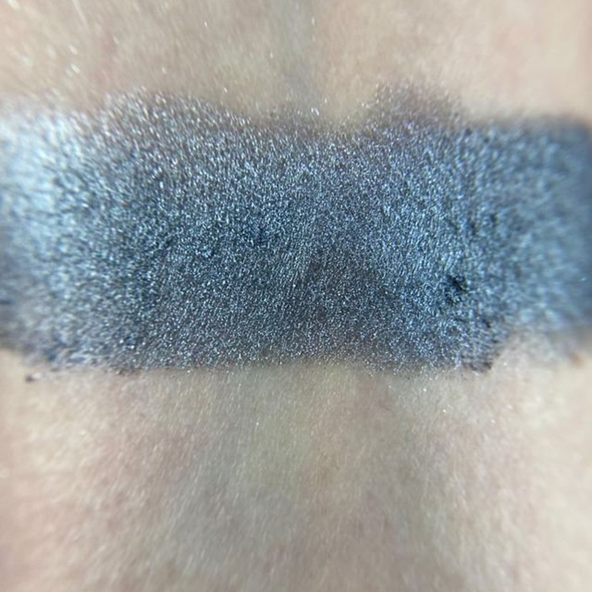 Single compact of matte gray eye shadow with sleek black packaging and silver logo