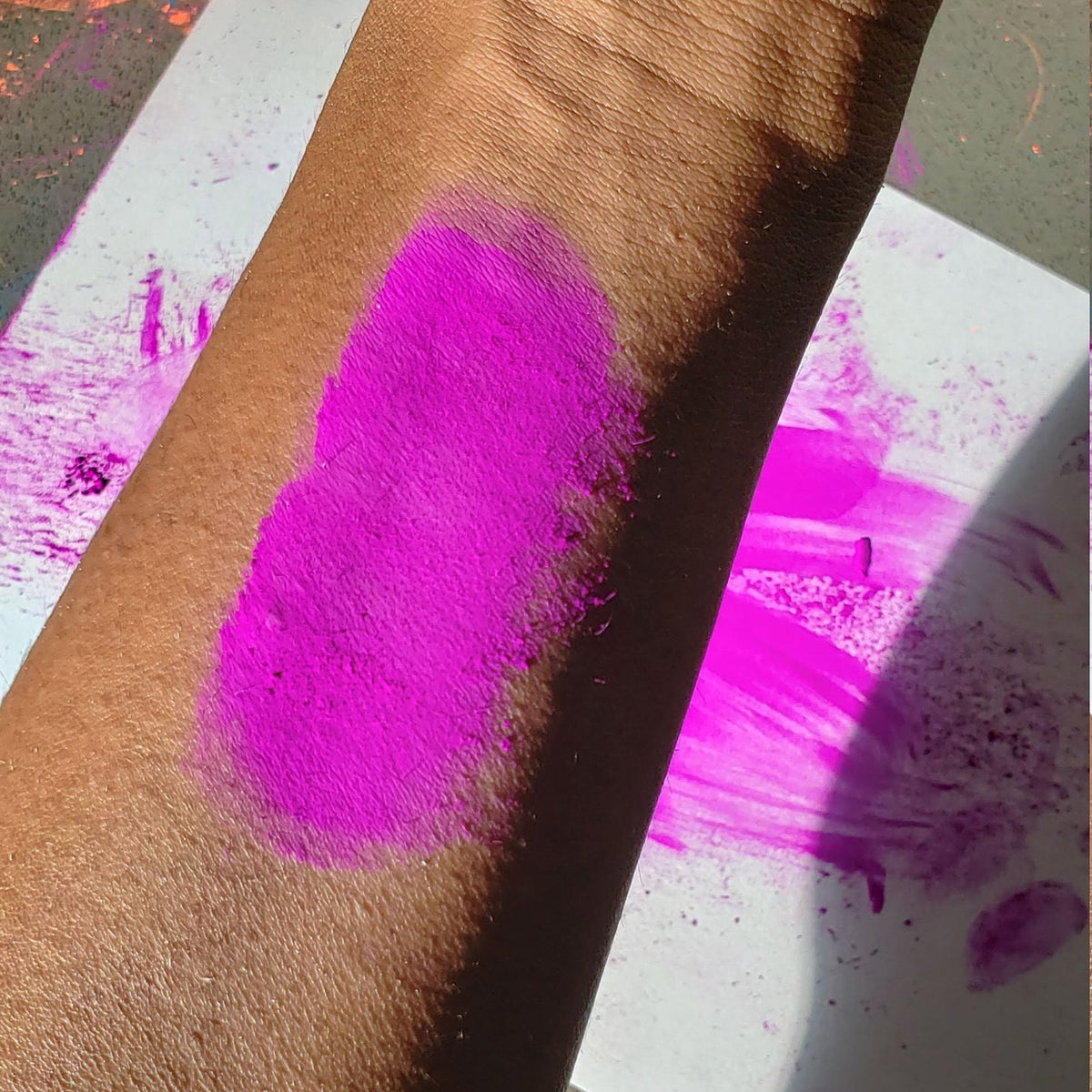 Vibrant neon purple eyeshadow pot with UV glow effect, perfect for festival makeup looks
