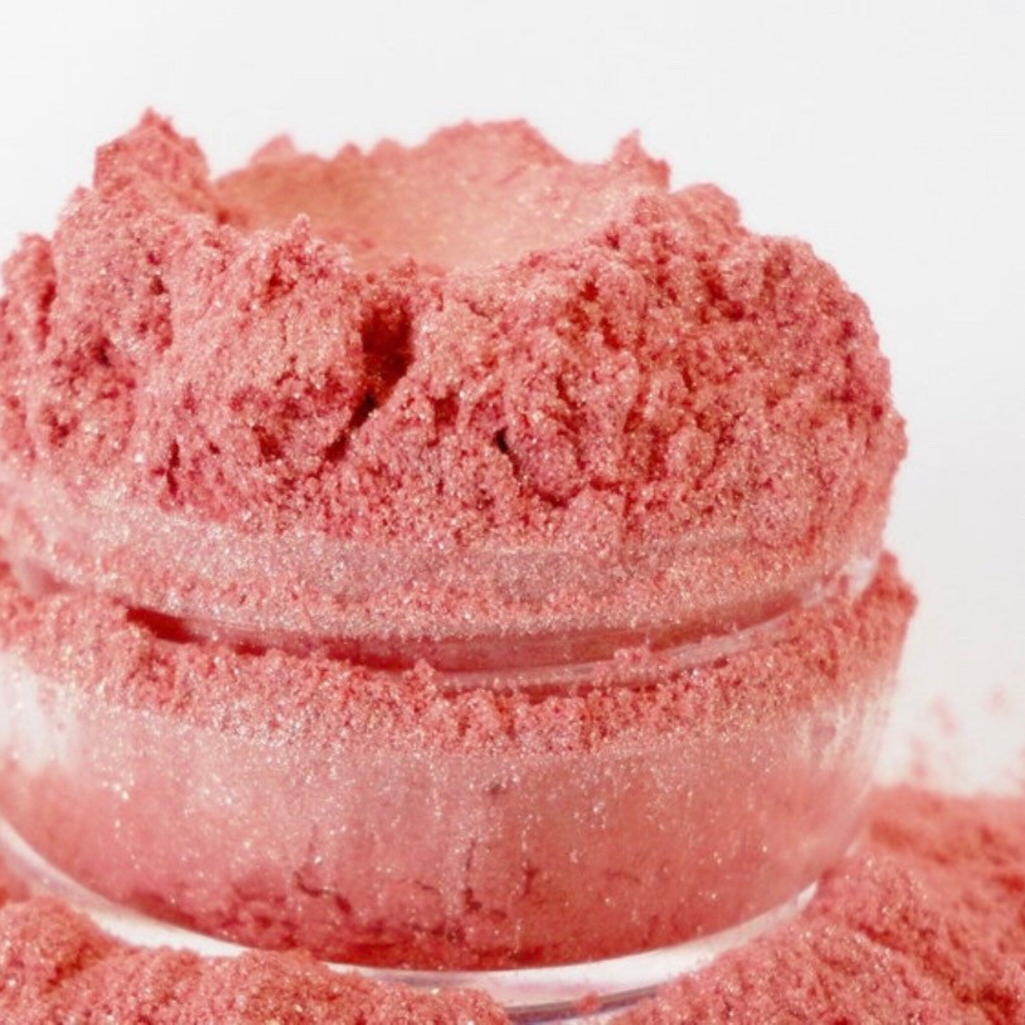 Side view of pink coral shimmer eye shadow in 10g sifter jar showing mineral makeup texture and natural glitter particles