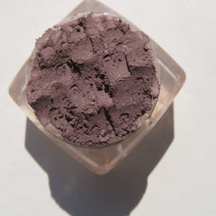 Close-up of matte nutmeg loose mineral eyeshadow with fine powder texture in eco-friendly packaging