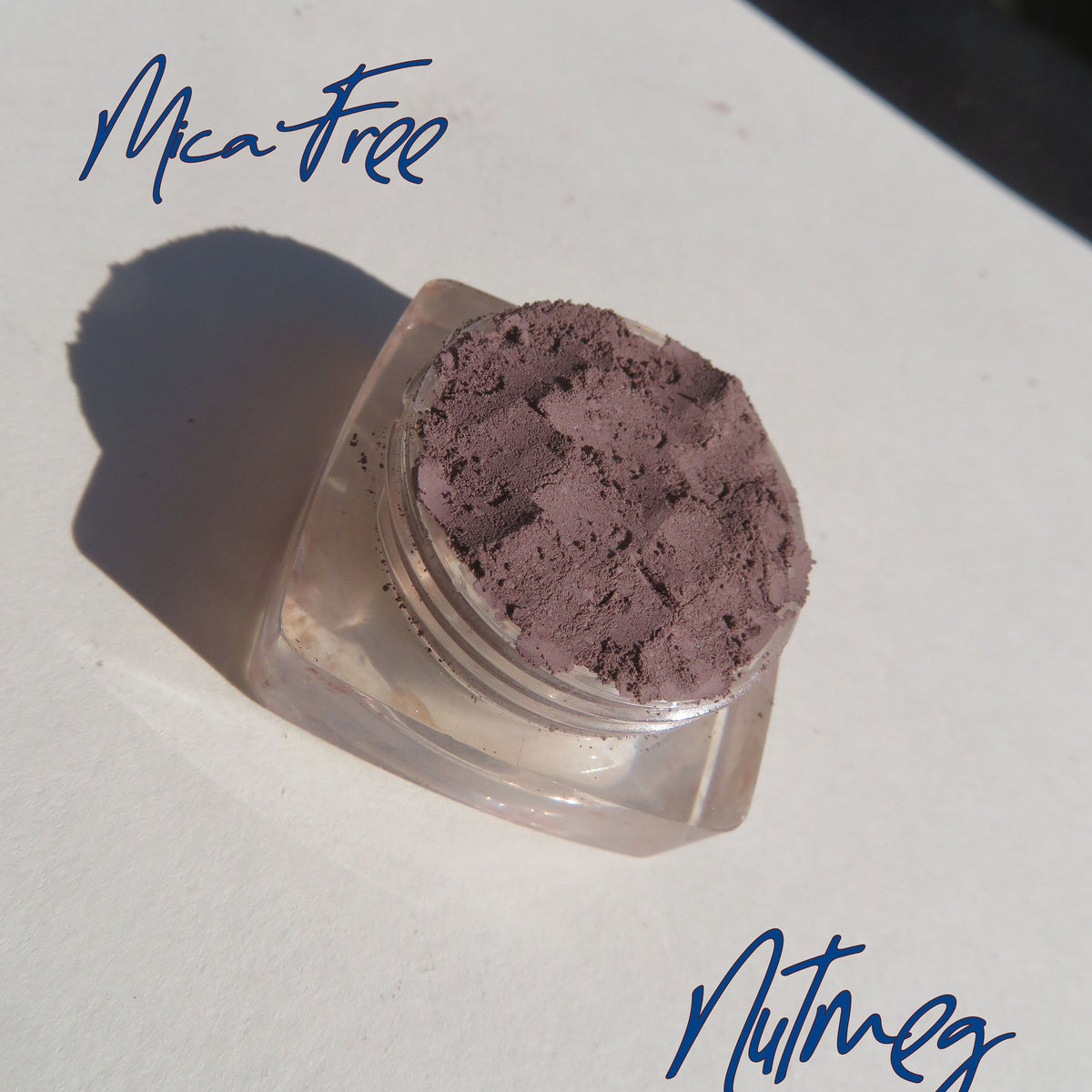 Open jar of matte nutmeg mineral eyeshadow with loose powder texture and eco-friendly packaging