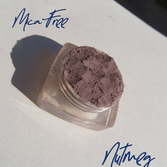 Open jar of matte nutmeg mineral eyeshadow with loose powder texture and eco-friendly packaging