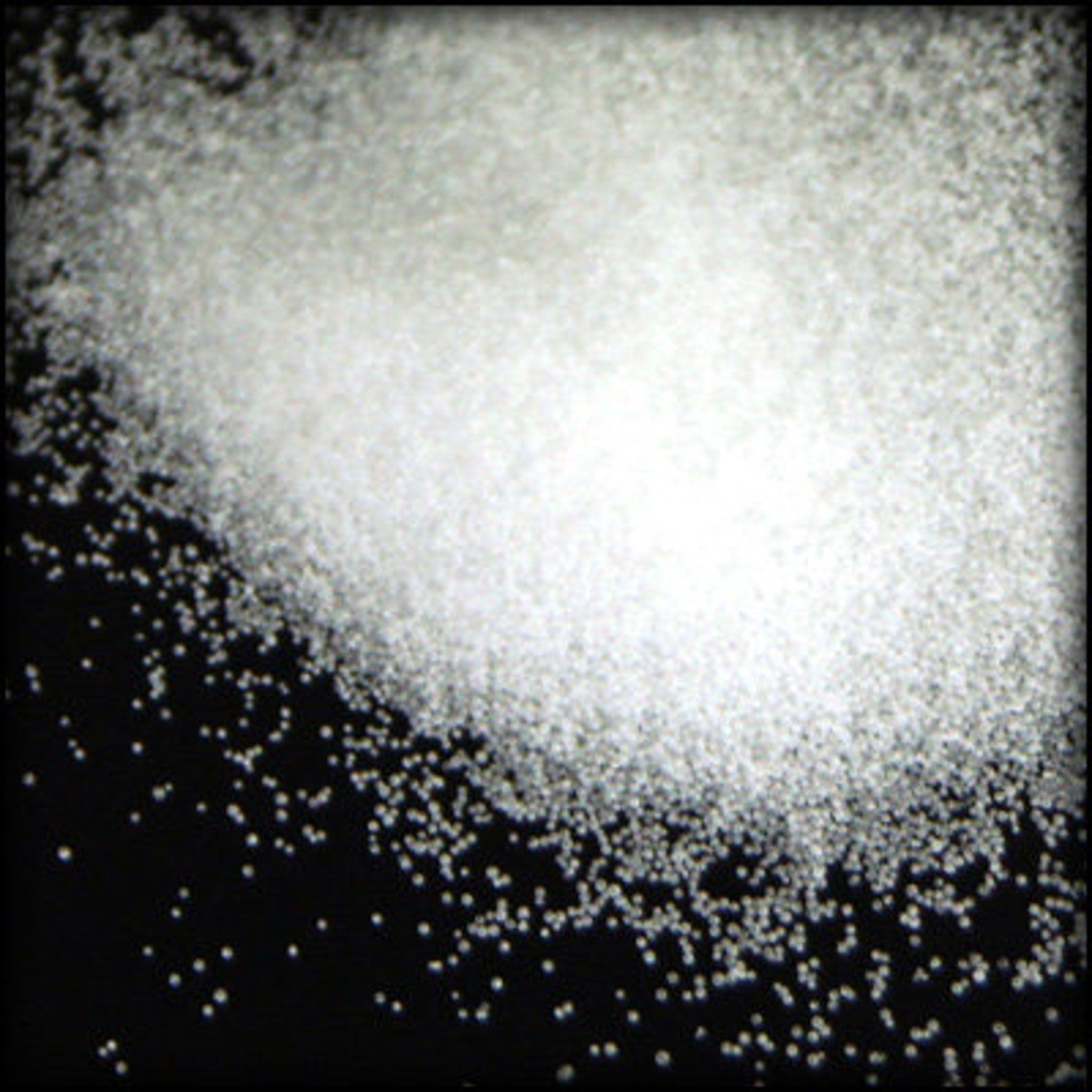 White granular material on black background, small particles, textured surface