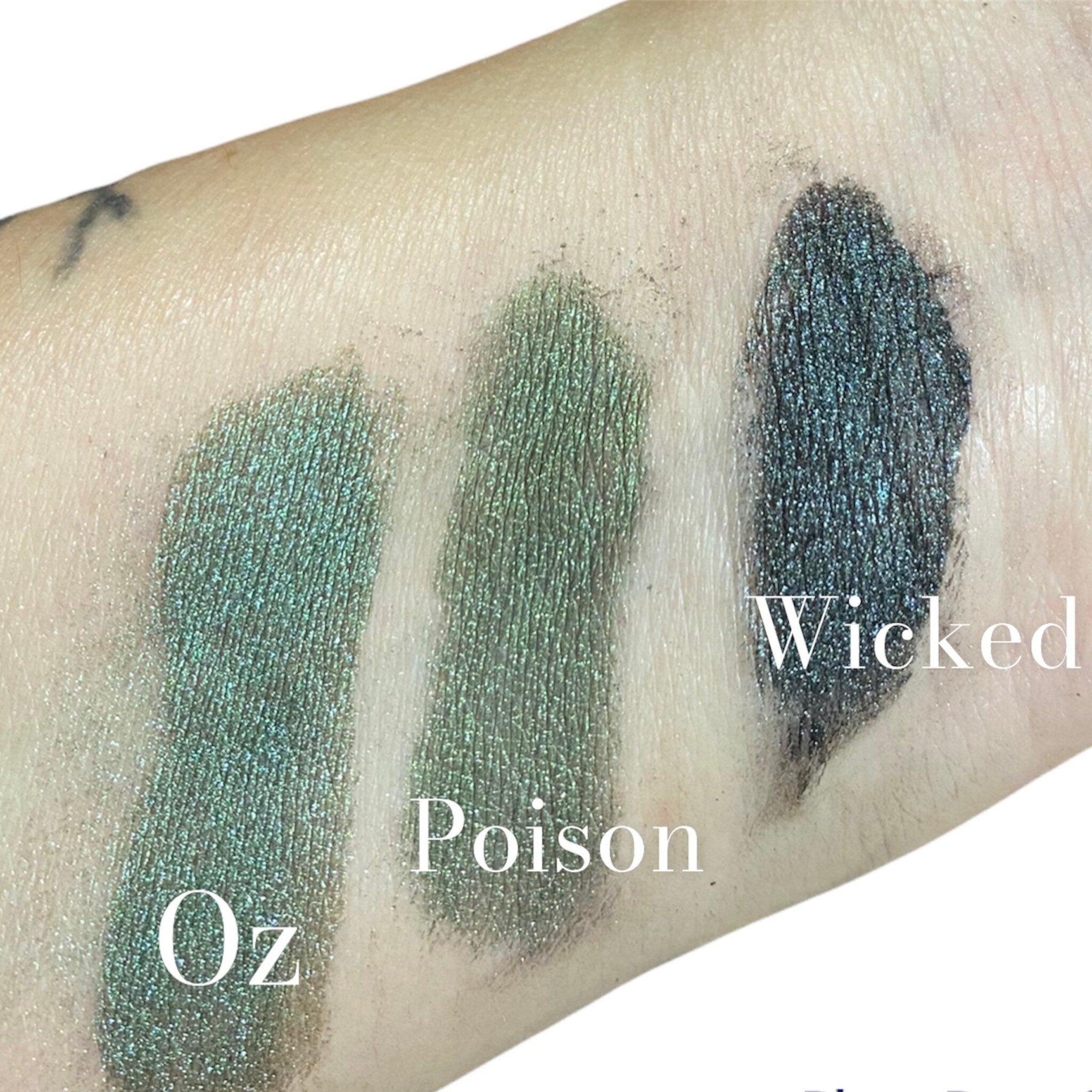 Side view of emerald green mineral eyeshadow in petite glass jar with gold lid, showcasing rich pigment texture