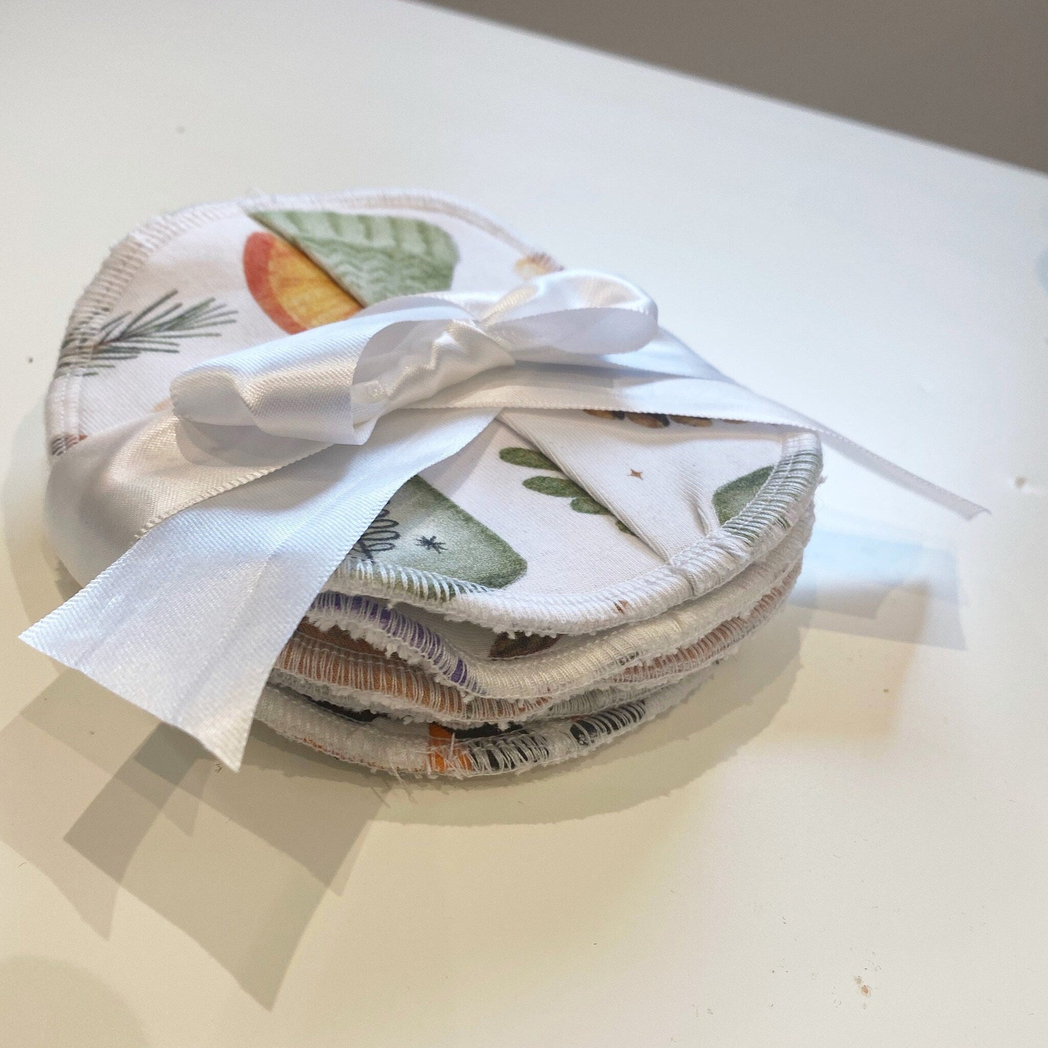 Reusable facial rounds with white ribbon, patterned cotton, and stitched edges
