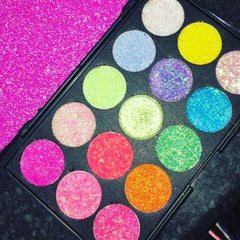 Close-up of fingertips applying shimmering silver glitter eye shadow to eyelid with soft blending brush