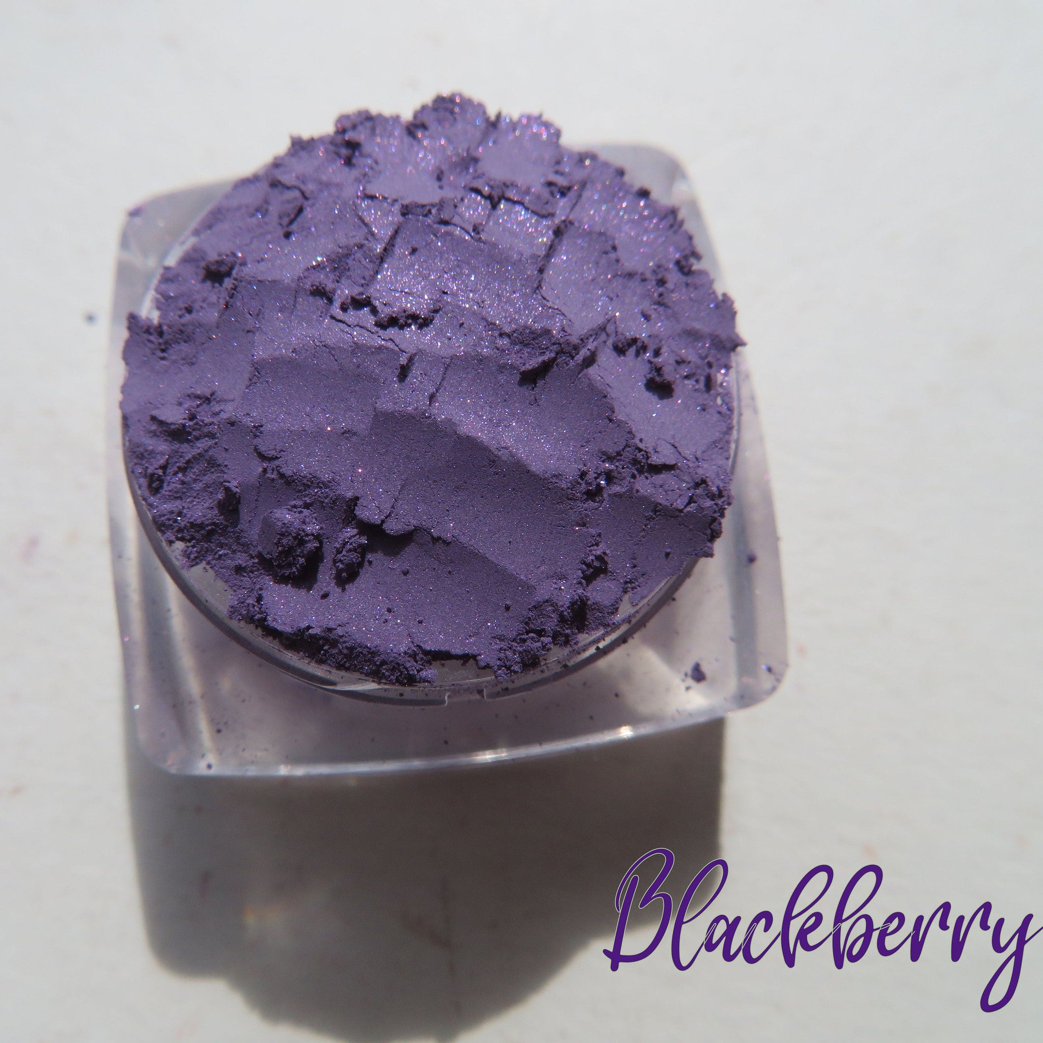 Side view of three purple shimmer loose pigment jars with vegan labels, showcasing sparkly texture