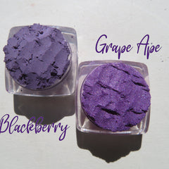 Close-up of three shimmering purple loose mineral eyeshadows with vegan sparkly pigments in a gift set.