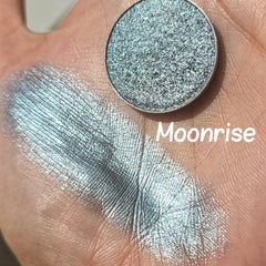 Extreme close-up of Moonrise Chameleon Eye Shadow showing icy blue to grey color shift with sparkling shimmer particles