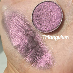 Hand applying multichrome eyeshadow in shifting orange, pink, and violet hues with olive undertones using a brush