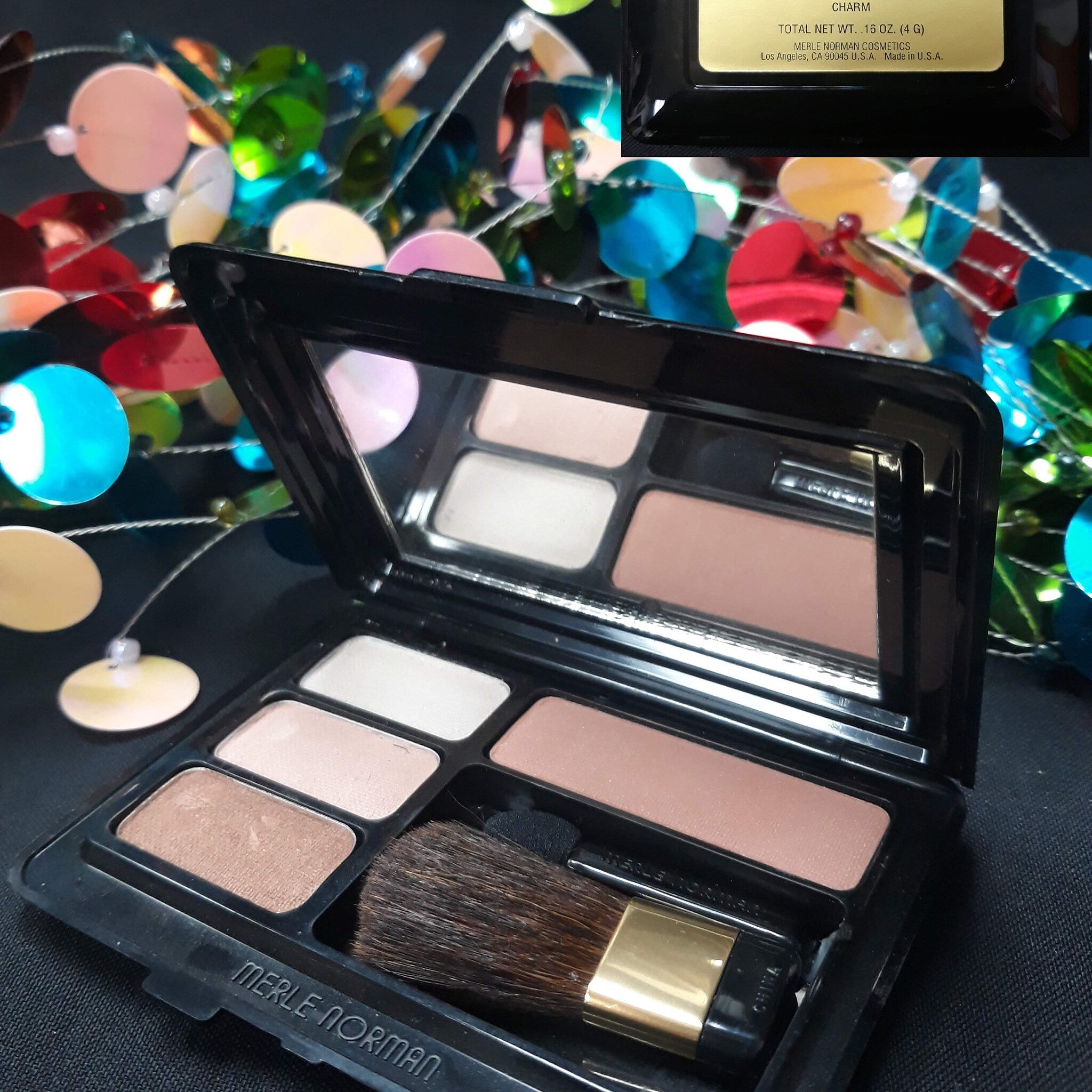 Merle Norman eyeshadow palette with black case, brown and beige shades, and brush