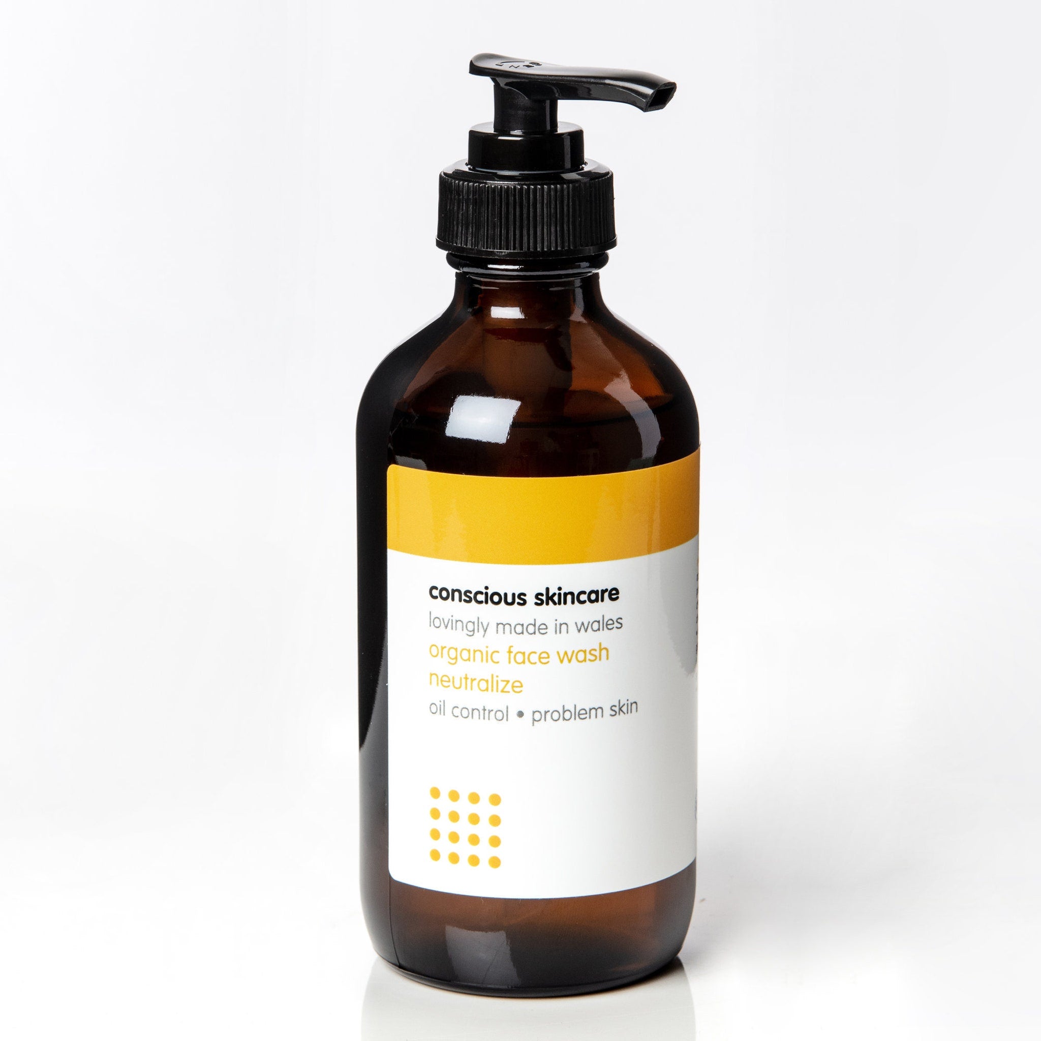 Face wash bottle with brown glass, black pump, and white label with text