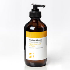 Face wash bottle with brown glass, black pump, and white label with text