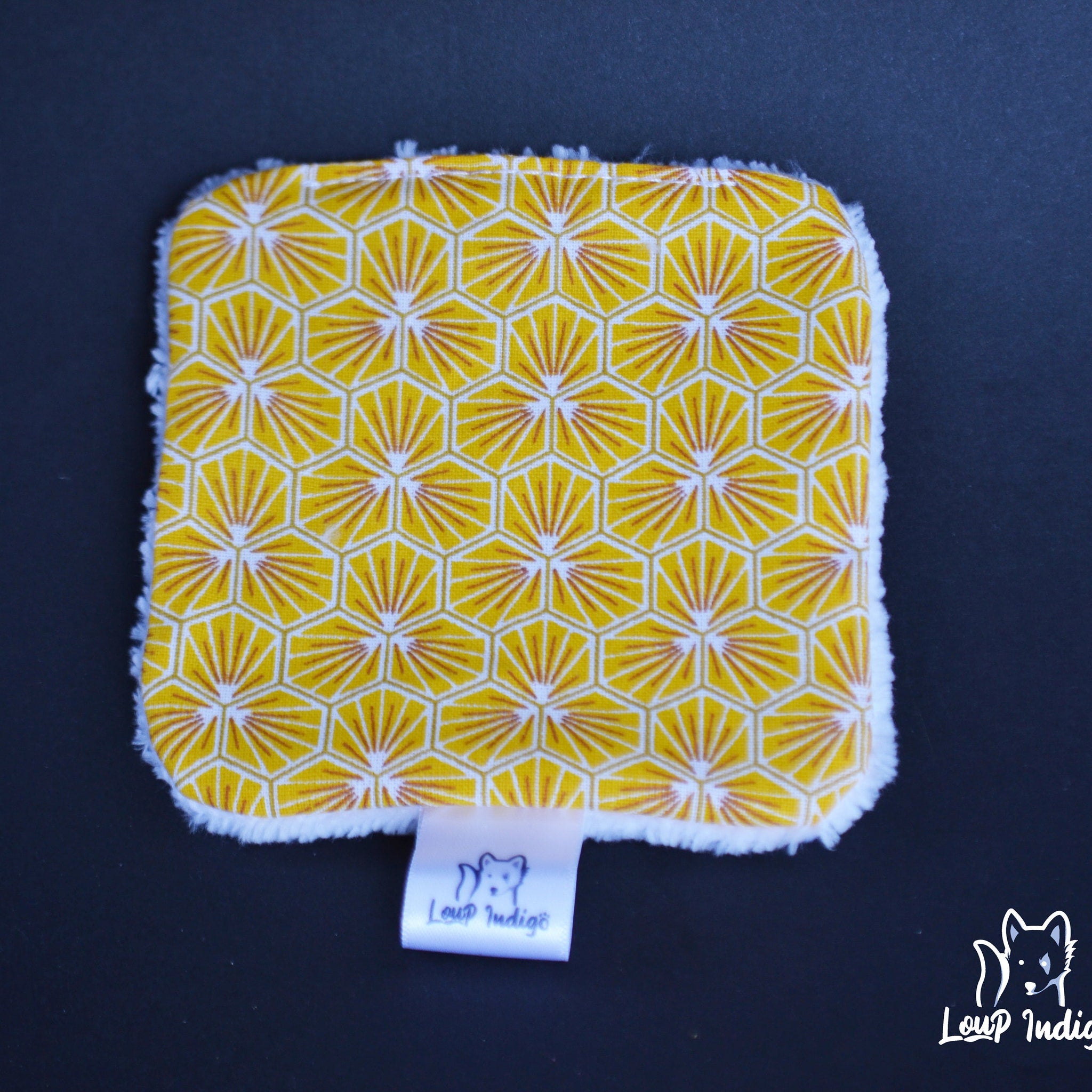 Yellow patterned fabric with white trim, Loup Indigo label visible on black background