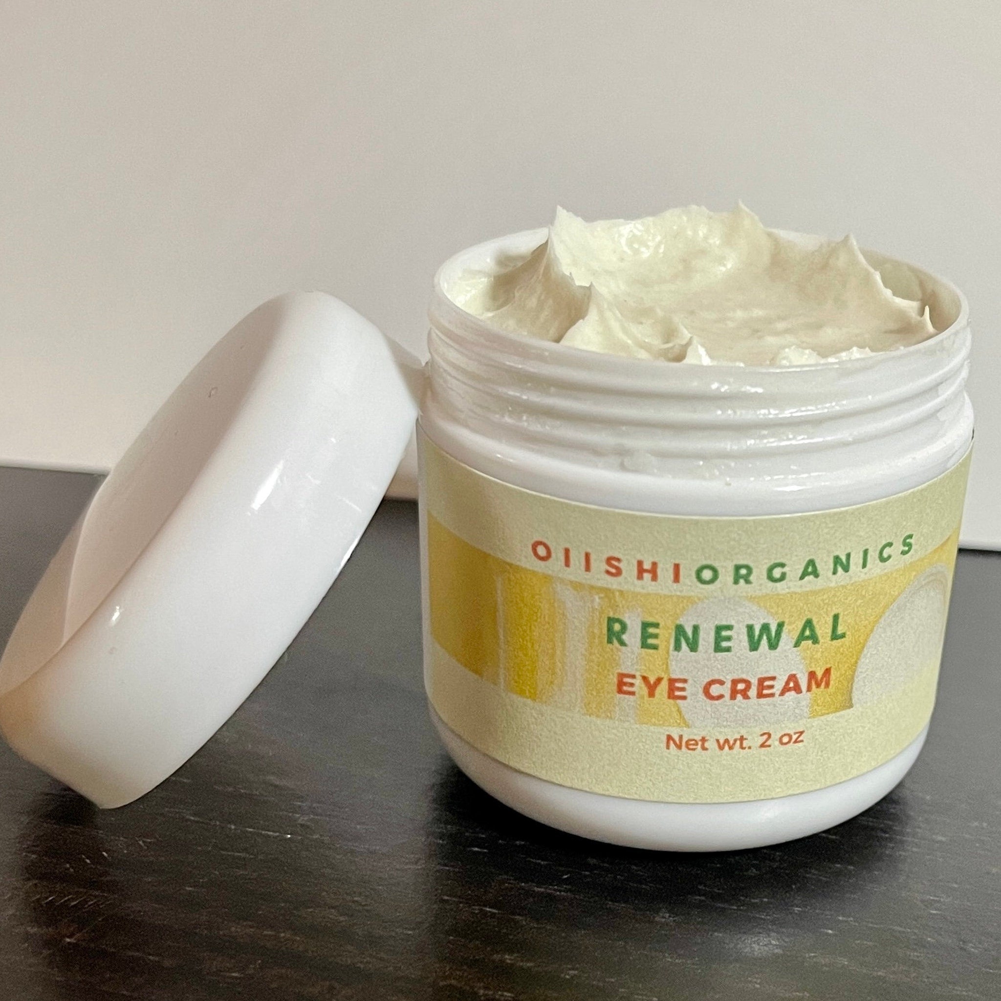 Eye cream jar with white cream, white plastic container, and OIIISHIORGANICS label