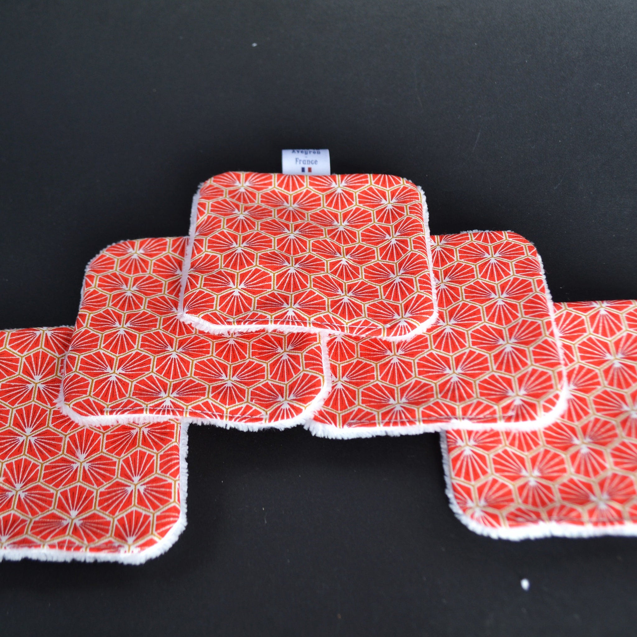 Reusable face pads with red and gold geometric pattern, white trim, and Avegros France label