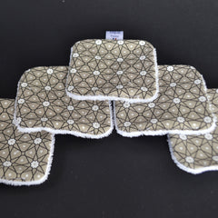 Reusable face pads with geometric pattern, tan fabric, white trim, Avegron France label visible
