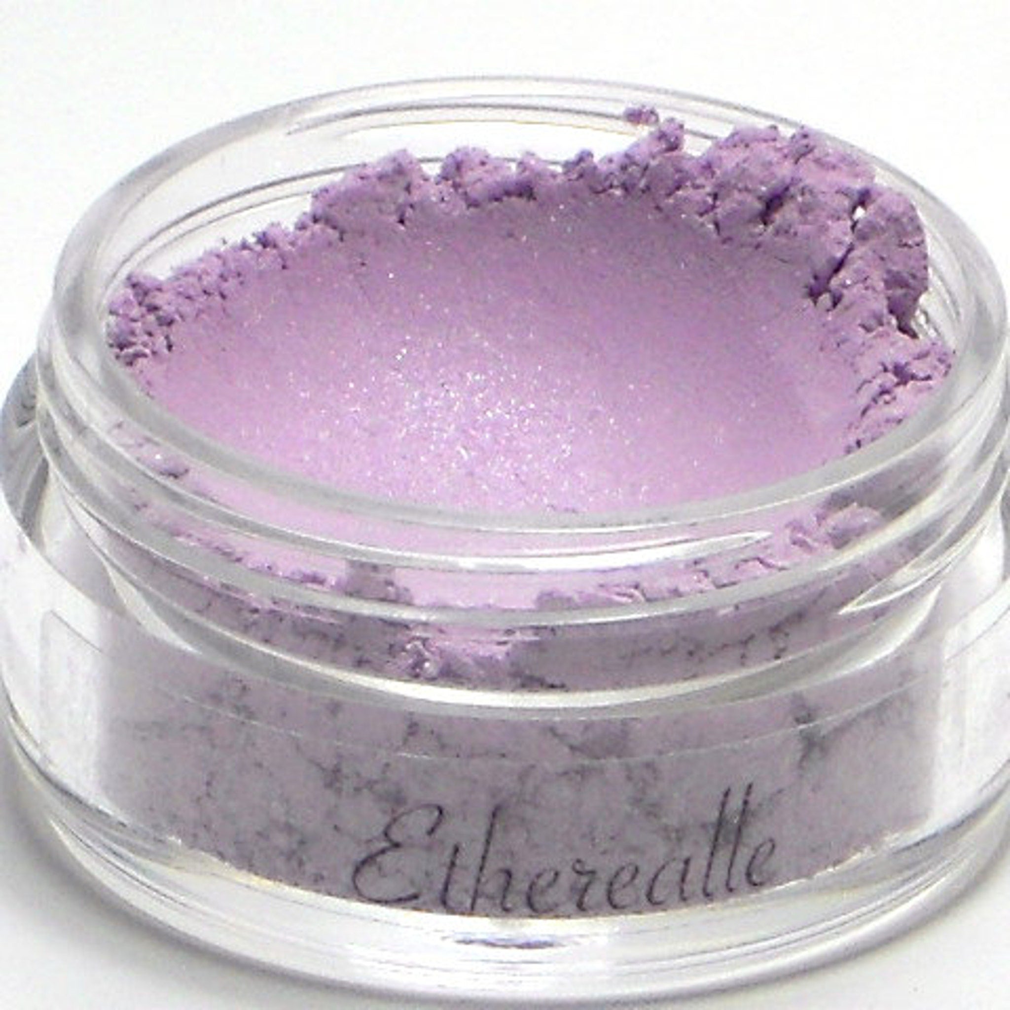 Eye shadow powder in light purple color with clear jar, Etherealle brand name visible