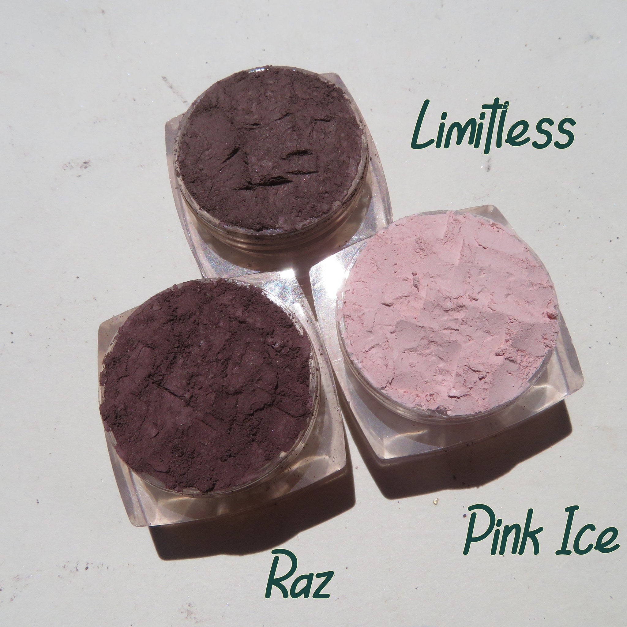 Side view of three vegan matte mineral eyeshadow pots showing loose pigment textures in earthy tones