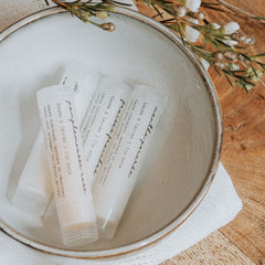 Lip balms in white tubes with text, in a ceramic bowl, La Marcotterie brand