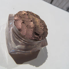 Close-up of loose mineral eyeshadow in shimmering dark brown with metallic rose undertones, vegan and talc-free