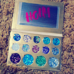 Close-up of glitter eye shadow palette with vibrant shimmering pigments in assorted colors
