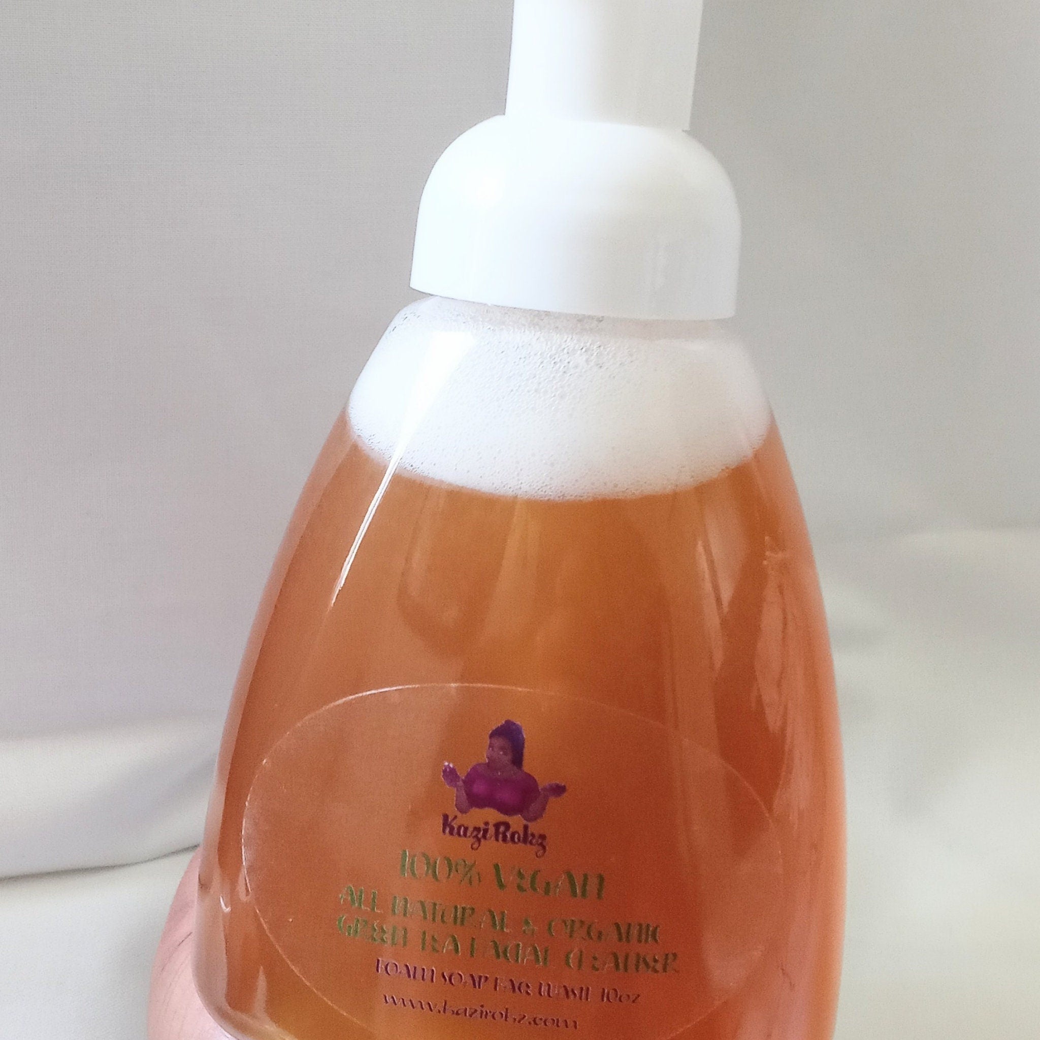 Foam soap bottle with white cap, orange liquid, and Kazi Rokz label