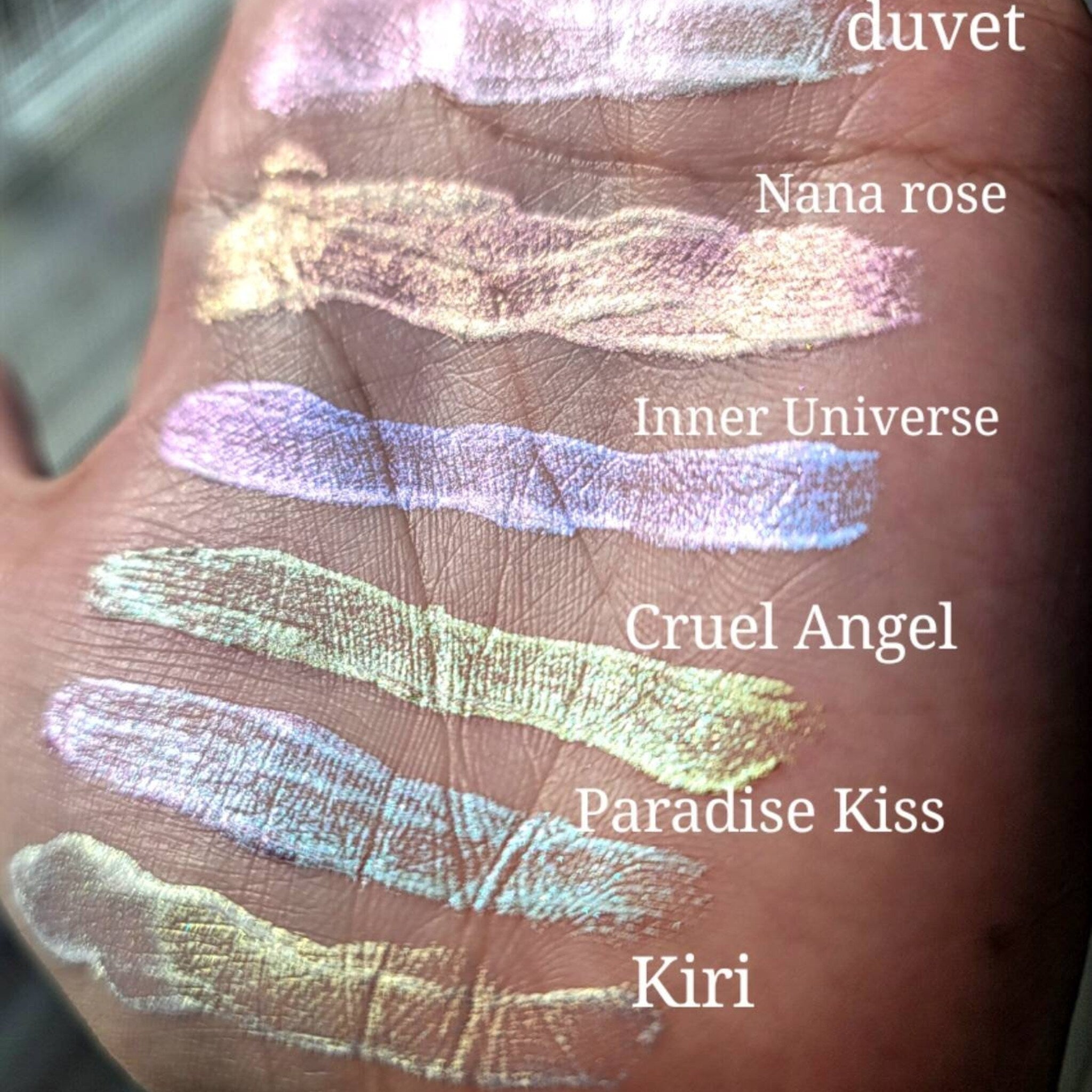 Side view of three chameleon duochrome liquid eyeshadows in glass bottles with doe-foot applicators, showcasing shimmery finishes.