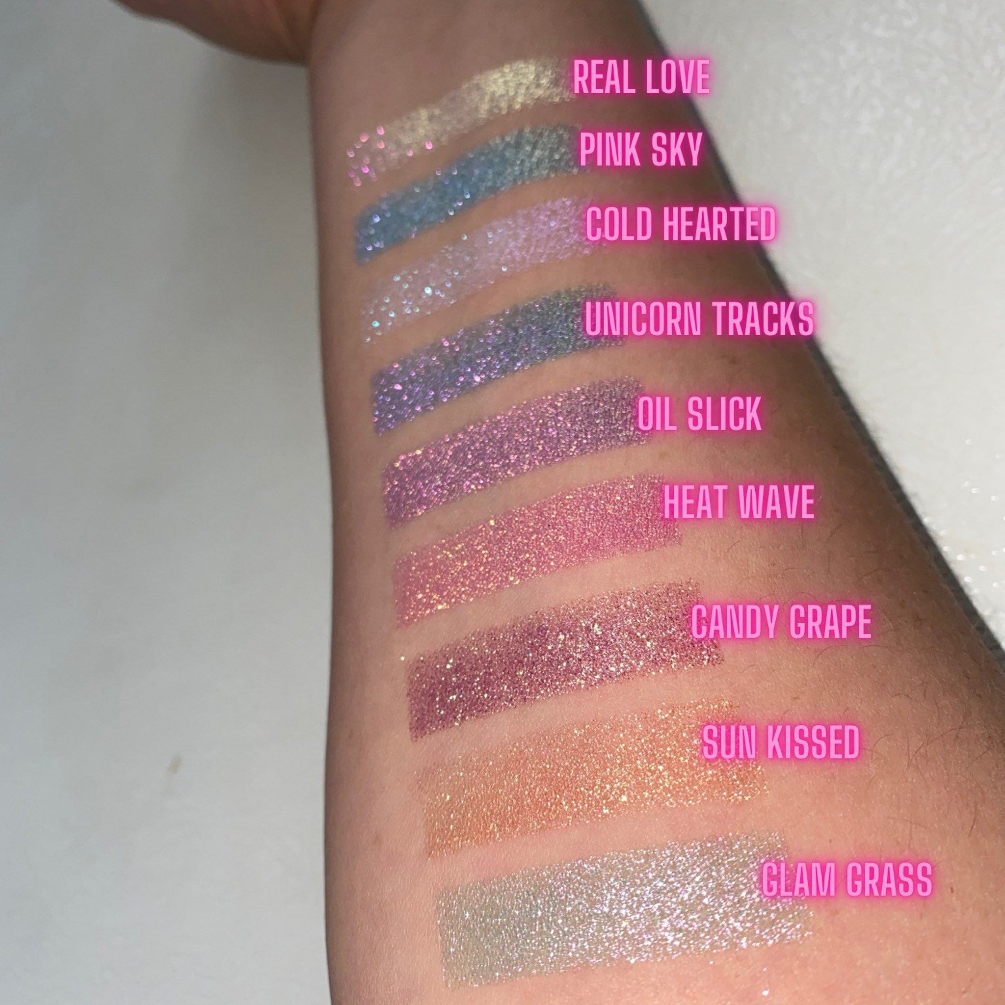 Side view of multichrome unicorn tracks eyeshadow showing shifting iridescent hues from violet to teal in compact pan