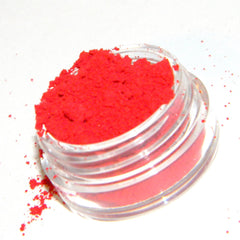 Close-up of matte red eye shadow pan with smooth, velvety texture in a sleek black compact.