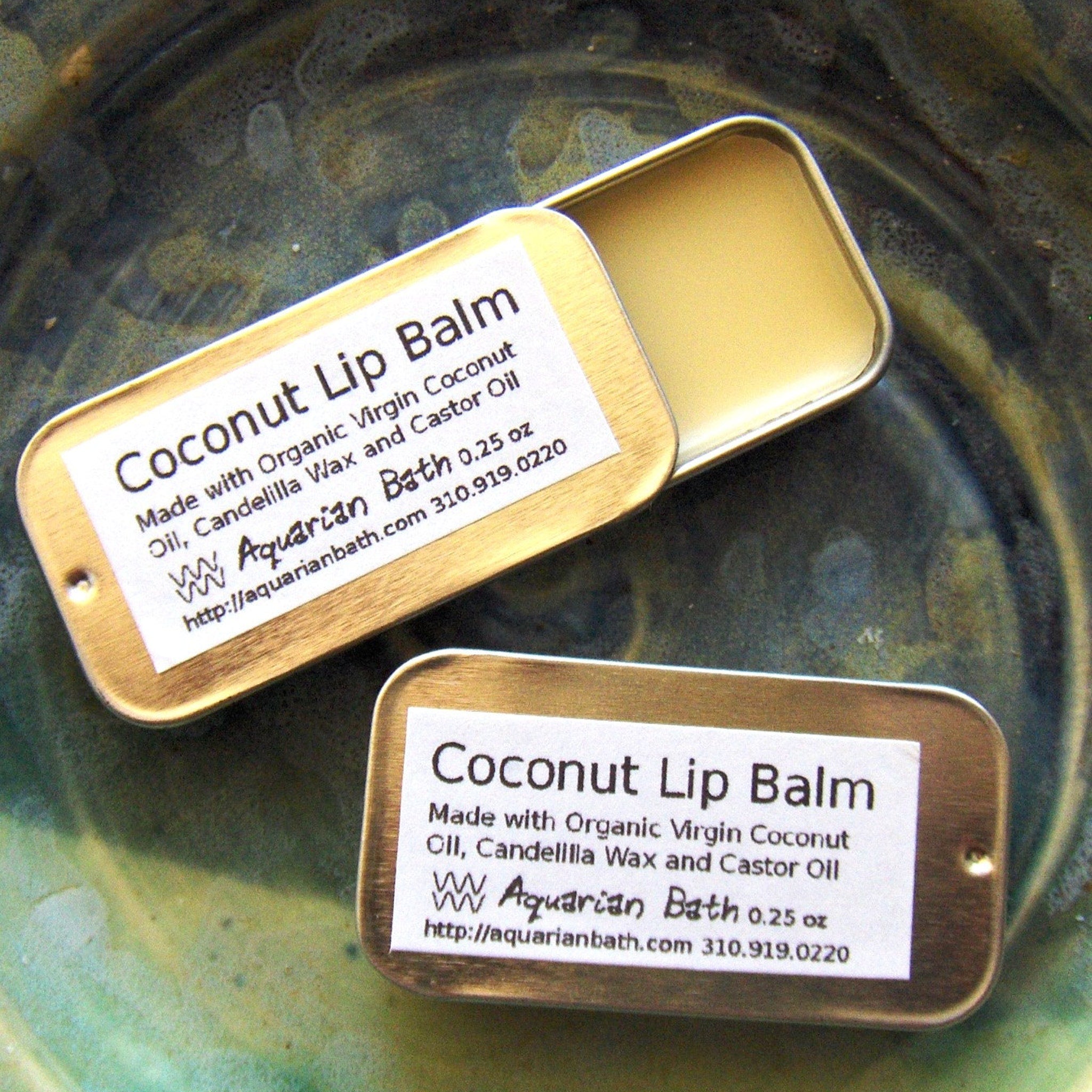 Lip balm in gold metal tin with Aquarian Bath label, open to show balm